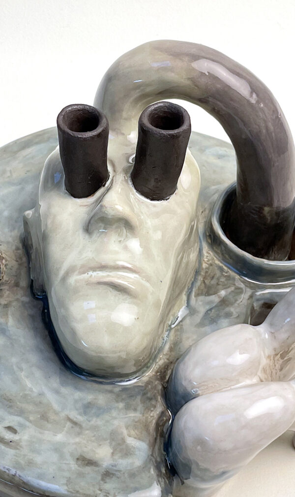 Sculpture Water Watcher. Plate with a selfportrait looking at the sky trough black tubes. Standing in the blue water are female abstract figures